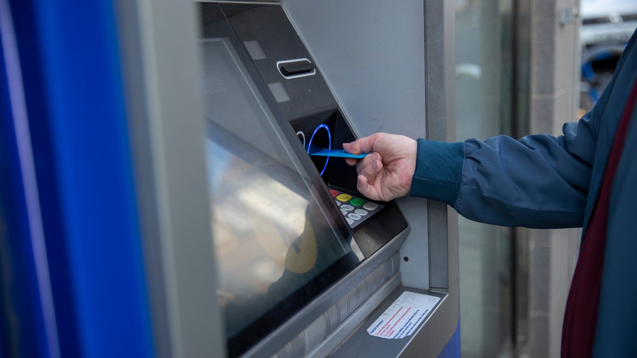 Un uomo utilizza un bancomat