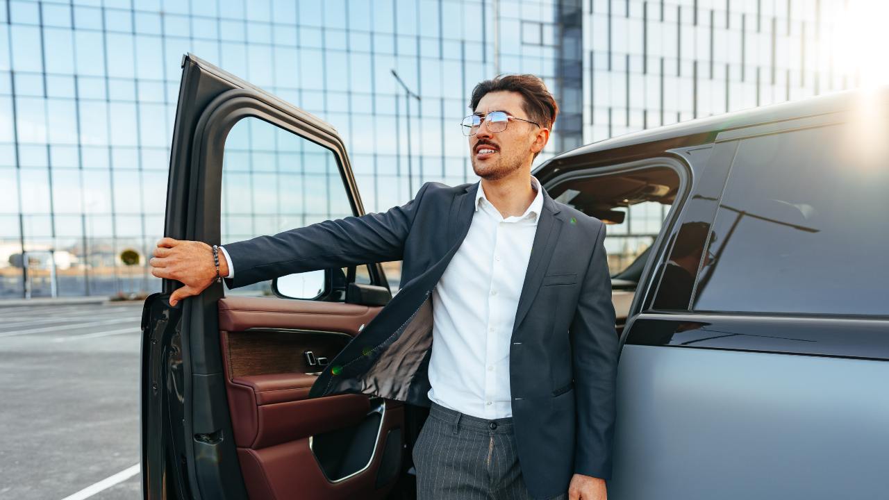 Un signore sta per chiudere lo sportello della propria auto.