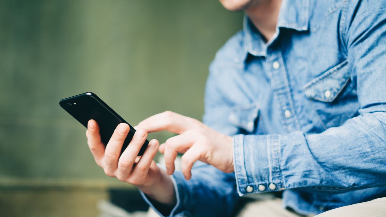 Ragazzo digita qualcosa sul proprio cellulare