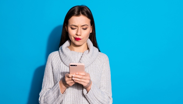 Ragazza osserva dubbiosa il proprio smartphone