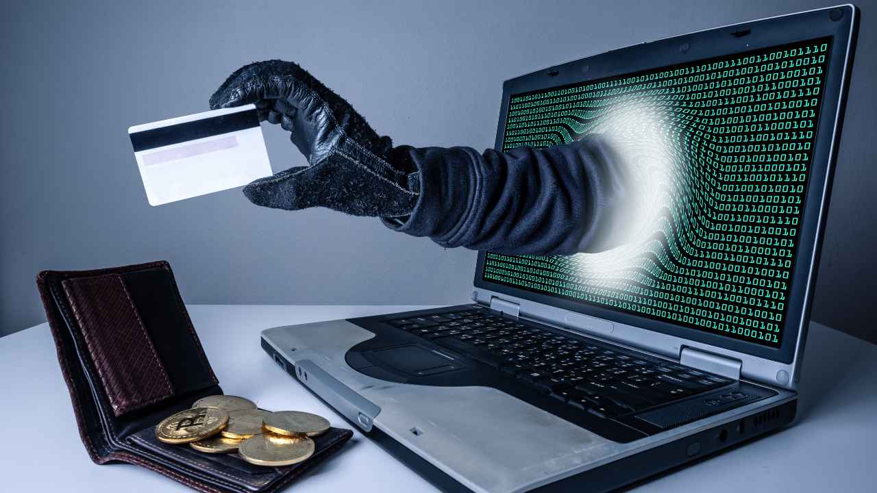 Un furto digitale, simbolizzato da un hacker che ci ruba il portafoglio